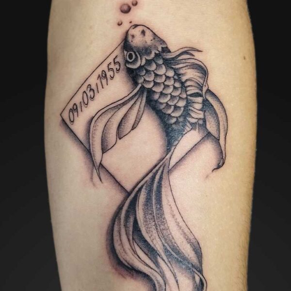 julia black and grey goldfish memorial tattoo Black and grey goldfish memorial tattoo with date banner by Julia at Atticus Tattoo, Calgary
