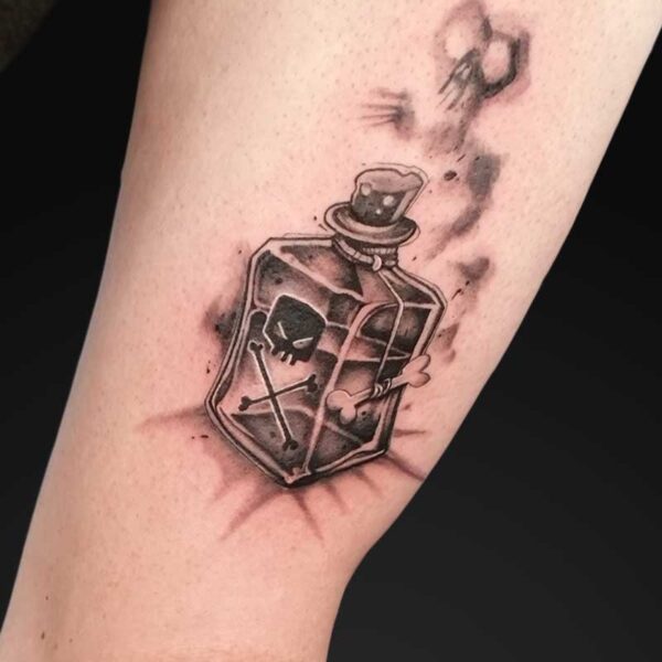 julia graphic poison bottle tattoo Graphic black and grey poison bottle tattoo with skull and crossbones by Julia at Atticus Tattoo, Calgary