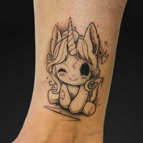 julia illustrative unicorn plush tattoo Illustrative winking unicorn plush ankle tattoo by Julia at Atticus Tattoo, Calgary