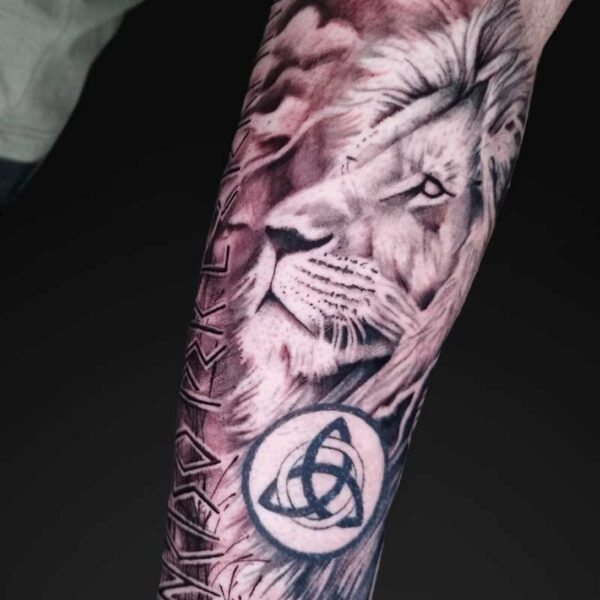 julia realism lion forearm tattoo Realism lion forearm tattoo with runes and triquetra by Julia at Atticus Tattoo, Calgary
